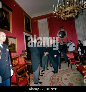 Staatsbegräbnis von Präsident Kennedy: Weißes Haus, nach Beerdigung Empfang. Jacqueline Kennedy und Senator Edward M. Kennedy (Massachusetts) begrüßen die Gäste bei einem Empfang im Weißen Haus nach dem Staatsbegräbnis von Präsident John F. Kennedy; Frau Kennedy schüttelt die Hände mit Bundeskanzler Ludwig Erhard. Ebenfalls im Bild: Prinz Gholam-Reza Pahlavi vom Iran; Botschafter des Iran, Mahmoud Foroughi; Minister für Außenbeziehungen von El Salvador, Dr. Hector Escobar Serrano; US-Chef des Protokolls, Angier Biddle Duke. Red Room, White House, Washington, D.C. Stockfoto