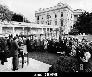 Besuch der Delegierten der Sitzung 1963, Verwaltungsrat des Beratenden Ausschusses für Poststudien, Universelle Postunion, 9:35am Uhr. Präsident John F. Kennedy (links, an einem Rednerpult) hält an internationalen Delegierten Bemerkungen zur Universellen Post-Unionu0027s 1963-Sitzung des Verwaltungsrats des Beratenden Ausschusses für Poststudien. Der stellvertretende Generalpostmeister, Sidney W. Bishop, steht links von Präsident Kennedy; die Korrespondentin des Weißen Hauses für United Press International (UPI), Helen Thomas, steht ganz rechts. Rose Garden, White House, Washington, D.C. Stockfoto