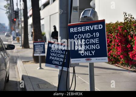 Los Angeles, CA USA - 10. Februar 2020: Parkplatzmesser in der Nähe eines Krankenhauses mit Schildern, die nur für Covid-19-Impfpatienten reserviert sind Stockfoto
