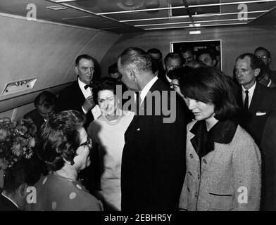 Reise nach Texas: Vereidigung an Bord der Air Force One, Lyndon B. Johnson (LBJ) als Präsident. Beamte versammeln sich in Air Force One für die Vereidigung von Präsident Lyndon B. Johnson im Love Field in Dallas, Texas, nach der Ermordung von Präsident John F. Kennedy. Von links nach rechts: Stellvertretender Pressesprecher, Malcolm Kilduff (unten links, Gesicht versteckt); Medienkontakt, Jack Valenti; Richterin Sarah T. Hughes; Repräsentant Albert Thomas (Texas); First Lady Bird Johnson; Präsident Johnson; Präsident Kennedyu2019s persönliche Sekretärin, Evelyn Lincoln (meist versteckt); ehemalige First Lady, Bondine Stockfoto