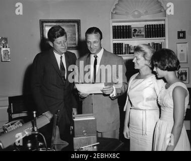 Besuch von Stan Musial, Major League Baseball (MLB) Spieler für die St. Louis Cardinals, und Familie, 4:10pm Uhr. Präsident John F. Kennedy und Stan Musial (Mitte), Major League Baseball (MLB) Spieler für die St. Louis Cardinals, sehen Sie sich ein handsigniertes Foto an, das Präsident Kennedy Mr. Musial während eines Besuchs im Oval Office überreichte. Herr Musialu0027s Frau, Lillian Musial, und Tochter, Janet Musial, schauen von rechts. White House, Washington, D.C. Stockfoto