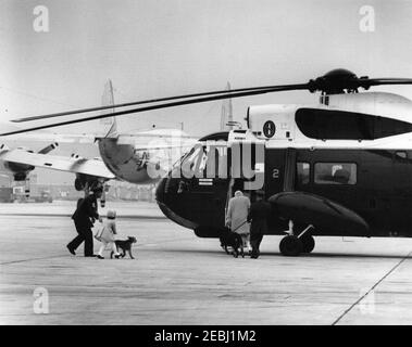 Präsident Kennedy kommt von Palm Beach, Florida, um 3:43pm Uhr auf der Andrews Air Force Base an. First Lady Jacqueline Kennedy und John F. Kennedy, Jr. (meist versteckt), besteigen einen Hubschrauber der United States Army, nachdem sie von Palm Beach, Florida aus auf der Andrews Air Force Base angekommen sind. Caroline Kennedy (mit Kennedy Familienhund, Charlie) geht links. Maryland. Stockfoto