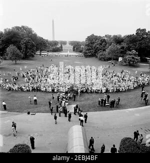 Besuch der Teilnehmer der Wahlkampfkonferenz für Demokratische Frauen 1962, 9:35am Uhr. Besuch der Teilnehmer der Wahlkampfkonferenz für demokratische Frauen 1962; Präsident John F. Kennedy und First Lady Jacqueline Kennedy treten von der Plattform (rechts). Ebenfalls im Bild: Vizepräsidentin des Demokratischen Nationalkomitees (DNC), Margaret B. Price; Vizepräsident Lyndon B. Johnson; Senator Hubert H. Humphrey (Minnesota); Vorsitzender des DNC, John M. Bailey; Senator Mike Mansfield (Montana); Senator George Smathers (Florida); Repräsentant Hale Boggs (Louisiana); Repräsentant Carl Albert (Oklahoma) Stockfoto