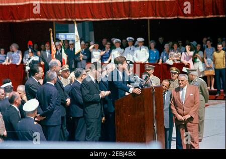 Reise nach Europa: Italien, Rom: Ankunft am Flughafen Fiumicino und Präsentation des Geschenks von Präsident Antonio Segni im Quirinale Palast. Präsident John F. Kennedy (auf einem Rednerpult) hält Bemerkungen am Flughafen Fiumicino bei seiner Ankunft in Rom, Italien. Ebenfalls abgebildet: Präsident von Italien, Antonio Segni; US-Chef des Protokolls, Angier Biddle Duke; Verteidigungsminister von Italien, Giulio Andreotti; italienischer Botschafter in den Vereinigten Staaten, Sergio Fenoaltea; US-Außenminister, Dean Rusk; Premierminister von Italien, Giovanni Leone; US-Außenministerium Dolmetscher, Neil Seidenman. Stockfoto