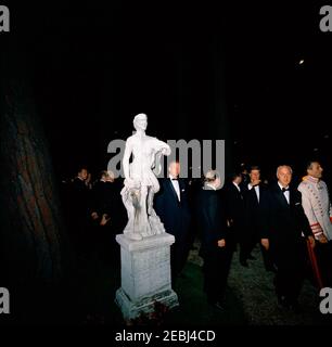 Europareise: Italien, Rom: Präsident Kennedy beim Abendessen im Quirinale Palace. Präsident Antonio Segni von Italien auch abgebildet. Präsident John F. Kennedy (Dritter von rechts) geht auf dem Gelände des Quirinale-Palastes in Rom, Italien, wo ein Abendessen zu seinen Ehren vom italienischen Präsidenten Antonio Segni gegeben wurde. White House Secret Service Agent, Art Godfrey, steht rechts von der Statue. Stockfoto