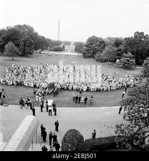 Besuch der Teilnehmer der Wahlkampfkonferenz für Demokratische Frauen 1962, 9:35am Uhr. Besuch der Teilnehmer der Wahlkampfkonferenz für demokratische Frauen 1962; Präsident John F. Kennedy und First Lady Jacqueline Kennedy stehen auf der Plattform (Mitte). Ebenfalls im Bild: Vizepräsidentin des Demokratischen Nationalkomitees (DNC), Margaret B. Price; Vizepräsident Lyndon B. Johnson; Senator Hubert H. Humphrey (Minnesota); Senator Mike Mansfield (Montana); Senator George Smathers (Florida); Repräsentant Hale Boggs (Louisiana); Repräsentant Carl Albert (Oklahoma); Washington Korrespondent für den Guy Stockfoto