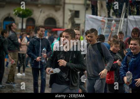 Lviv, Ukraine - 2. Mai 2016: Feier Wassergießen am Montag nach Ostern durch das Rathaus. Glückliche Jungen gießen Wasser auf Mädchen. Stockfoto