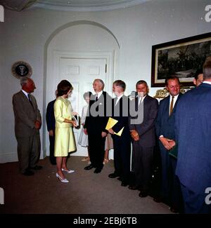 Präsentation des White House Guide Book 1st an Präsident Kennedy u0026 First Lady Jacqueline Kennedy (JBK), 4:25pm Uhr. Präsentation des neuen White House Guide Buchs an Präsident John F. Kennedy und First Lady Jacqueline Kennedy durch Mitglieder der National Geographic Society (NGS) und der White House Historical Association (WHHA); u0022The White House: An Historic Guide,u0022 eine gemeinsame Publikation der NGS und der WHA, wurde von Judd u0026 Detweiler, Inc. Gedruckt.Links nach rechts: Präsident und Herausgeber der NGS, Dr. Melville Bell Grosvenor; Vorsitzender der Fine Arts Commission und Vorsitzender der t Stockfoto