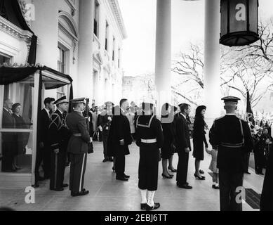 Staatsfuneral von Präsident Kennedy: Abfahrt vom Weißen Haus und Prozession zum Kapitol der Vereinigten Staaten. Jacqueline Kennedy steht mit ihren Kindern, Caroline Kennedy und John F. Kennedy, Jr., im Nordportico, vor der Trauerprozession von Präsident John F. Kennedy vom Weißen Haus zum Kapitolgebäude. Hinter Mrs. Kennedy stehen: Generalstaatsanwalt Robert F. Kennedy; Jean Kennedy Smith; Patricia Kennedy Lawford; Präsident Lyndon B. Johnson; Prinzessin Lee Radziwill von Polen; Jamie Auchincloss; Janet Auchincloss; Hugh D. Auchincloss; Geheimagent des Weißen Hauses, Ru Stockfoto