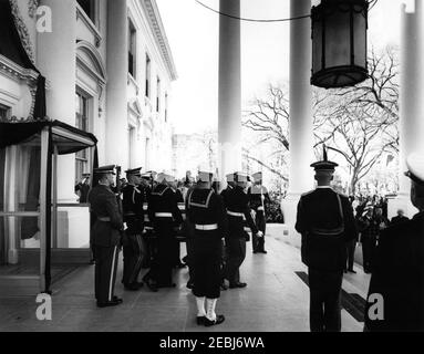 Staatsfuneral von Präsident Kennedy: Abfahrt vom Weißen Haus und Prozession zum Kapitol der Vereinigten Staaten. Ehrengäste tragen die Fahnenschal von Präsident John F. Kennedy vom Nordeingang des Weißen Hauses, vor einer Trauerprozession zum Kapitolgebäude. Naval Aide to President Kennedy, Captain Tazewell Shepard, grüßt rechts; White House Secret Service Agenten, Clint Hill und Gerald A. u201cJerryu201d Behn, stehen rechts im Hintergrund. Mitglieder der Ehrenwache stehen auf der Hut; Mitglieder der Presse beobachten. Zu den Pallbearern gehören: Lance Corporal Jer Stockfoto