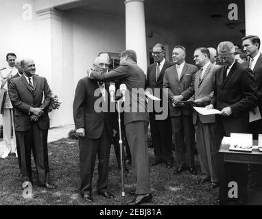 Verleihung der Distinguished Civilian Service Awards Presidentu2019s, 12:00pm Uhr. Verleihung des Preises Presidentu2019s für den ausgezeichneten Zivildienst des Bundes. Präsident John F. Kennedy überreicht die Auszeichnung an den Präsidenten der Bundesvereinigung der Hypothekenbanken der HHFA, J. Stanley Baughman (Mitte links). Blick auf (L-R): Naval Aide to the President, Captain Tazewell T. Shepard, Jr. (ganz hinten); Preisträger und Direktor des bemannten Raumfahrtzentrums, Dr. Robert Gilruth (meist versteckt); Administrator der HHFA, Robert C. Weaver Stockfoto