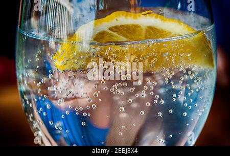 Kaltes Erfrischungsgetränk in einem Glas mit Mineralwasser, Eis und Zitrone. Stockfoto