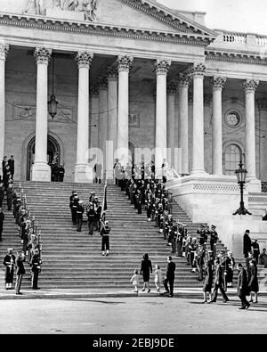 Staatsfuneral von Präsident Kennedy: Abfahrt vom Weißen Haus und Prozession zum Kapitol der Vereinigten Staaten. Ehrengäste tragen die Fahnenschatulle von Präsident John F. Kennedy die Stufen des Kapitolgebäudes hinauf, nach einer Trauerprozession vom Weißen Haus. Jacqueline Kennedy geht mit ihren Kindern Caroline Kennedy und John F. Kennedy, Jr., und Generalstaatsanwalt Robert F. Kennedy ins Zentrum. Hinter Mrs. Kennedy: Jean Kennedy Smith; Steve Smith; Patricia Kennedy Lawford; und White House Secret Service Agent, Clint Hill. Zu den Pallbearern gehören: Lance Corporal Jer Stockfoto