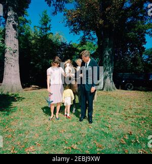 Präsident Kennedy, First Lady Jacqueline Kennedy (JBK), Caroline Kennedy (CBK) u0026 John F. Kennedy, Jr. (JFK, Jr.), mit Pony u201cLeprechaunu201d, Geschenk des irischen Präsidenten u00c9amon de Valera. Präsident John F. Kennedy, First Lady Jacqueline Kennedy und ihre Kinder, Caroline Kennedy und John F. Kennedy, Jr., stehen mit einem Connemara Pony, Leprechaun, als Geschenk des Präsidenten von Irland, u00c9amon de Valera. South Lawn, White House, Washington, D.C. Stockfoto