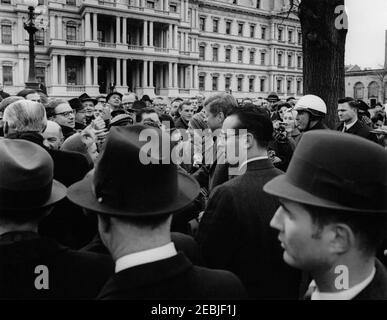 Eröffnungszeremonie für Jorge Alessandri Rodru00edguez, Präsident von Chile, 11:15am Uhr. Präsident John F. Kennedy (Mitte rechts, teilweise in der Menschenmenge versteckt) und Präsident von Chile, Jorge Alessandri Rodru00edguez (ganz links, mit dem Rücken zur Kamera), begrüßen die Besucher vor dem Blair House nach den Ankunftszeremonien zu Ehren von Präsident Alessandri Rodru00edguez. Ebenfalls im Bild: Dolmetscher des US-Außenministeriums, Fernando van Reigersberg; Geheimagenten des Weißen Hauses, Charlie Kunkel und Toby Chandler. Washington, D.C. Stockfoto