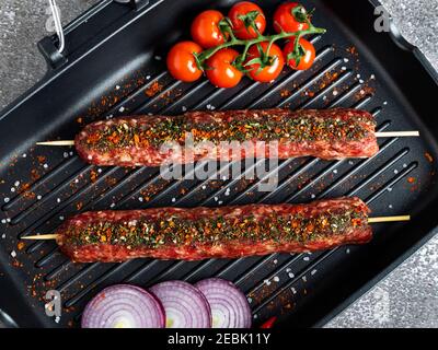 lula Kebab Rohes Rinderlamm auf Bratpfanne Grill, Gewürze, Draufsicht, Nahaufnahme Stockfoto