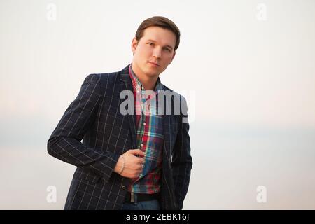 Junge gut aussehende Geschäftsmann zu Fuß im Freien stilvolle Mode-Modell in Schwarzer Anzugblazer und kariertes Hemd Stockfoto