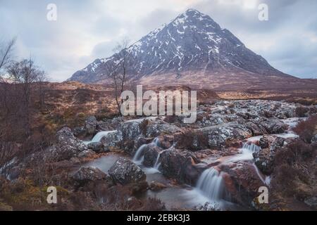 Moody Landschaft des berühmten Buachaille Etiv Mor und River Coupall Wasserfall in Glencoe in den schottischen Highlands. Stockfoto