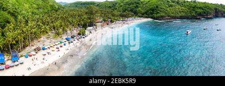 Herrliche Luftpanorama-Foto des tropischen Strandes am Ende des Bergtals mit Kokospalmen, Boote im blauen Wasser im Ozean, Seitenansicht Stockfoto