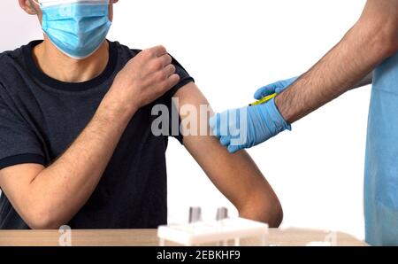 Impfung gegen Coronavirus. Der Arzt impft einen grauhaarigen Mann. COVID-19. Banner. Isolieren. Impfstoffrückgewinnung, Krankenhaus. Copyspace. Stockfoto