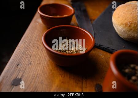 Nahaufnahme von verschiedenen Gewürzen in Schüsseln und einem Hamburger Brötchen auf einem Tisch Stockfoto