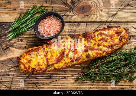 Pizza Sandwich auf Baguette Brot mit Schinken, Speck, Gemüse und Käse auf Holztisch. Holzhintergrund. Draufsicht Stockfoto