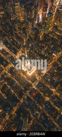 Atemberaubendes Porträt Luftaufnahme des Empire State Building bei Nacht in Manhattan, New York City bei Nacht mit glühenden Stadtlichtern Stockfoto