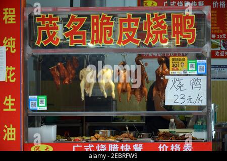 Kleines Geschäft, das verschiedene Fleischsorten im Qinghu Bezirk von Shenzhen, China verkauft. Gebratene Enten und Hühner sowie Schweinefleisch und Gemüse. Stockfoto