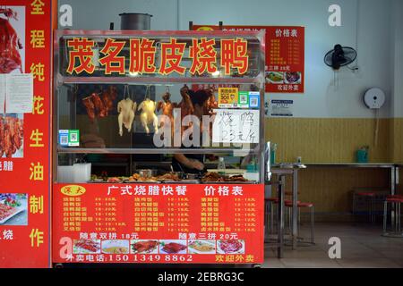 Kleines Geschäft, das verschiedene Fleischsorten im Qinghu Bezirk von Shenzhen, China verkauft. Gebratene Enten und Hühner sowie Schweinefleisch und Gemüse. Stockfoto