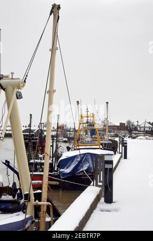 Fischerboote, die an einem verschneiten Tag in Boston Lincolnshire am Fluss witham ankern. Stockfoto