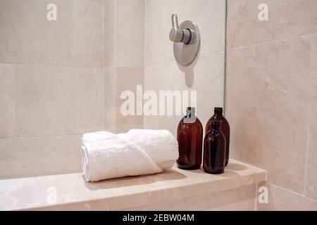 Bernstein Glas Shampoo-Flaschen ohne Pumpe in einem luxuriösen Marmor Hotel Spa und Dusche. Stockfoto