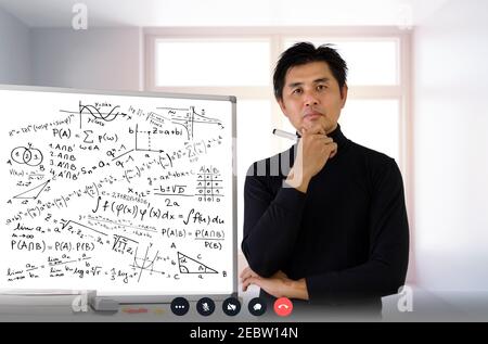 Reife Professor Lehre Mathematik an Studenten im Klassenzimmer. Lehrer Mann, der Mathematik Problem beim Schreiben auf Whiteboard mit Videokonferenz löst. C Stockfoto
