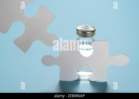 Fläschchen Covid-19-Impfstoff hinter Puzzles Stockfoto