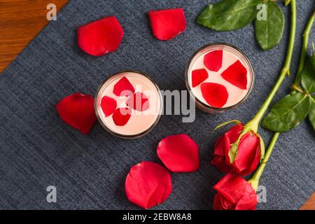 Rosenmilch , Rose Shake , Gulab Shake mit Rosenblüten indischen Valentinstag trinken mit herzförmigen roten Rosenblüten Kerala. Erdbeermilch schütteln Stockfoto