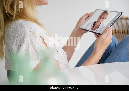 Frau mit Videoanruf mit Ärztin über digitale Tablette Stockfoto