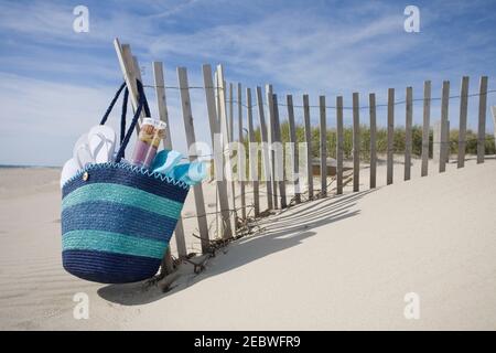 Strandtasche mit Flip-Flops am Strand Stockfoto