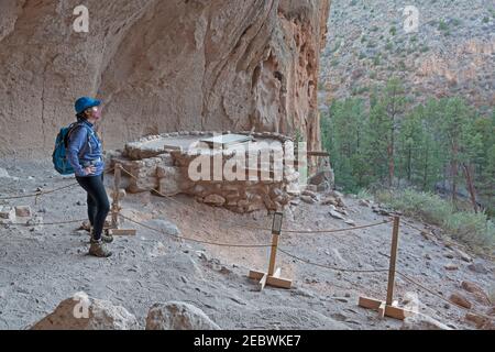 FRAU WANDERER TRÄGT GESICHTSMASKE AN DER NISCHE, KLIPPE WOHNUNG, BANDELIER NM, LOS ALAMOS, NM, USA Stockfoto