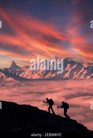 Schweiz, Kanton Wallis, Brig, Bergsteiger auf einem verschneiten Hang bei Sonnenaufgang Stockfoto