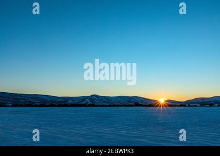 USA, Idaho, Bellevue, Sonnenuntergang über schneebedeckten Feldern und Bergen Stockfoto