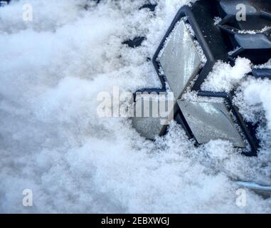 Mitsubishi-Logo auf dem Kühlergrill bedeckt von dem Schnee des gebrauchten und leicht schmutzigen japanischen Fahrzeug, geparkt in Gifhorn, Deutschland, Februar Stockfoto