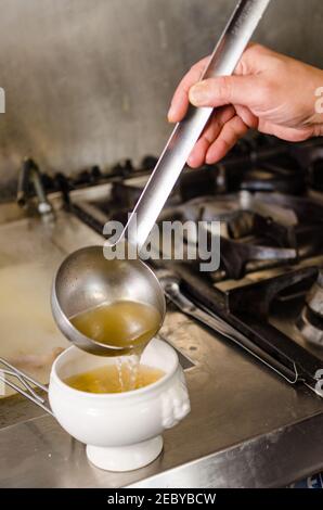 Serving Brühe in Marubini gefüllte Pasta bown in einem professionellen Küche Stockfoto