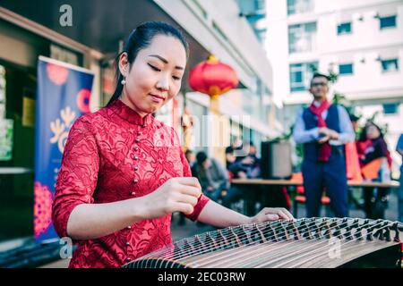 Wellington. Februar 2021, 13th. Ein Künstler des China Cultural Center in Wellington führt Guzheng-Musik für Bewohner im Wellington Central Park, Neuseeland, Feb,13, 2021. Die Gemeinschaftsfeier des chinesischen Neujahrs fand im Central Park von Wellington statt, mit chinesischer Musik, Traditionen und Segnungen. Quelle: Zhang Jianyong/Xinhua/Alamy Live News Stockfoto