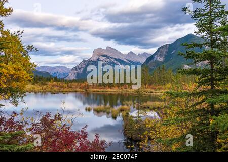 Vermilion Lakes Herbstlaub Landschaft in der Dämmerung. Banff National Park, Kanadische Rockies, Alberta, Kanada. Bunte Bäume in roten, gelben, goldenen Farben. Stockfoto