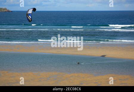 Kitesurfen Lektion, Cornwall. Eine Frau, die bei Ebbe am Strand von Riviere Sands an der Mündung der Hayle-Mündung das Kitesurfen lernt. Stockfoto