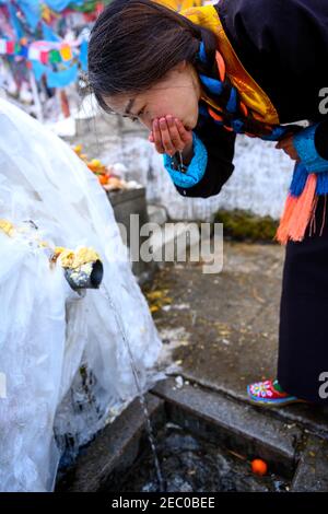 (210213) -- SHANNAN, 13. Februar 2021 (Xinhua) -- Kelyang trinkt "glückverheißendes Wasser", während sie am 12. Februar 2021, dem ersten Tag des tibetischen Neujahrs, um mit ihren Eltern in Shannan in der Autonomen Region Tibet im Südwesten Chinas zu beten. Der 12. Februar markiert den ersten Tag des tibetischen Neujahrs, der mit dem diesjährigen Frühlingsfest zusammenfiel. Am frühen Morgen zog Kelyang, 23, traditionelle tibetische Kostüme an und begleitete ihre Eltern, um zum Gebet durch die Berge zu spazieren.als Postgraduierte-Studentin der Beijing Normal University mit Schwerpunkt auf moderner und zeitgenössischer chinesischer Literatur, studierte Kely Stockfoto