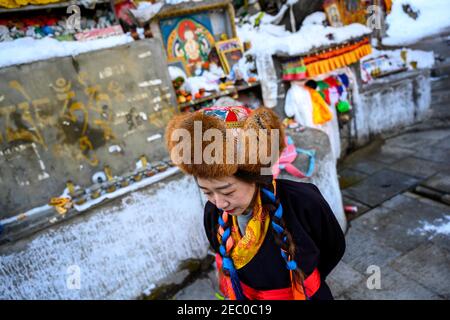 (210213) -- SHANNAN, 13. Februar 2021 (Xinhua) -- Kelyang wartet darauf, "glückverheißendes Wasser" zu bekommen, während sie am 12. Februar 2021, dem ersten Tag des tibetischen Neujahrs, in Shannan in der Autonomen Region Tibet im Südwesten Chinas, Berge umherwanderte, um mit ihren Eltern zu beten. Der 12. Februar markiert den ersten Tag des tibetischen Neujahrs, der mit dem diesjährigen Frühlingsfest zusammenfiel. Am frühen Morgen zog Kelyang, 23, traditionelle tibetische Kostüme an und begleitete ihre Eltern, um zum Gebet durch die Berge zu gehen.als Postgraduierte Studentin der Beijing Normal University studierte sie moderne und zeitgenössische chinesische Literatur Stockfoto