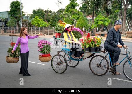 SA Dec Stadt, Dong Thap Provinz, Vietnam - 7. Februar 2021: Ein Mann fährt ein Dreirad mit Blumen während des Mondneujahres in Sa Dec Stadt, Dong T Stockfoto