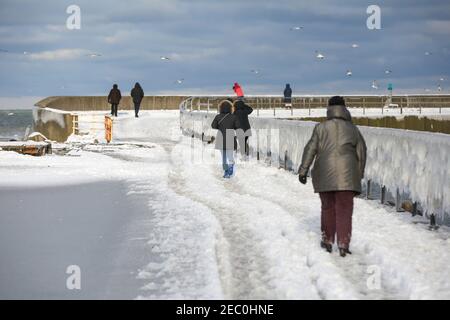 Gefrorenes Meerwasser ist an der Mole vom Leuchtturm Travemünde in Lübeck-Travemünde zu sehen. Stockfoto