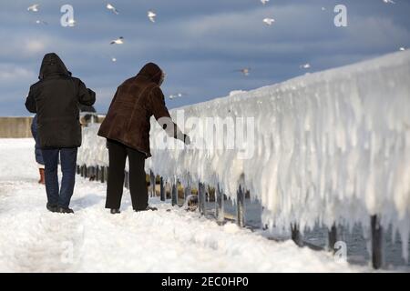 Gefrorenes Meerwasser ist an der Mole vom Leuchtturm Travemünde in Lübeck-Travemünde zu sehen. Stockfoto