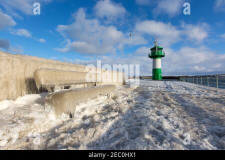 Gefrorenes Meerwasser ist an der Mole vom Leuchtturm Travemünde in Lübeck-Travemünde zu sehen. Stockfoto